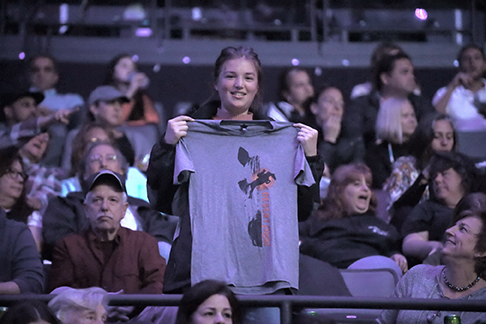 Mackenzie Wood holding up the Desert Flight t-shirt