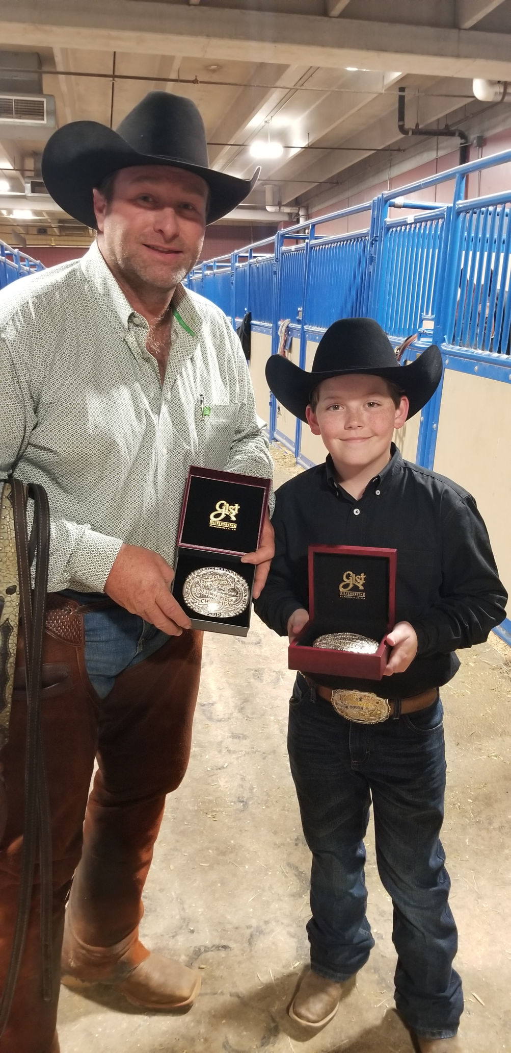 Casey Crouch and Aden Bernhagen show off their buckles during the National Cutting Horse Association World Finals.