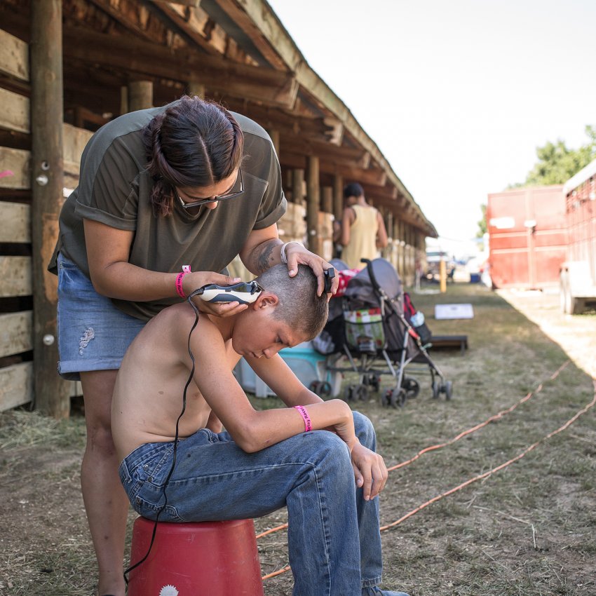 Ella Brewer giving Kayden Brings Plenty a trim (Nate Bressler)